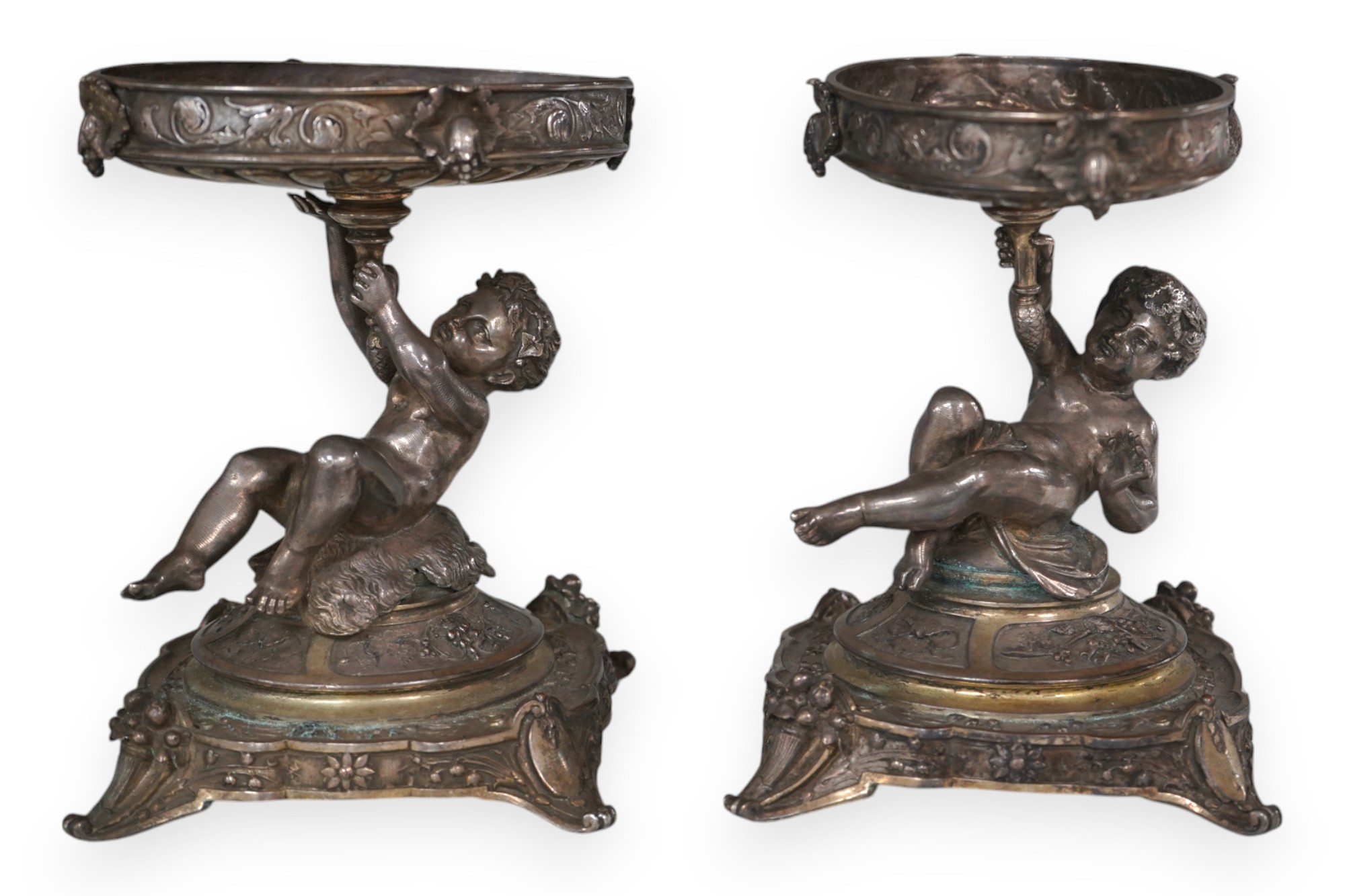 A pair of early 20th century Elkington & Co. silver plated ‘putti’ stands, 17cm. Condition - fair to good